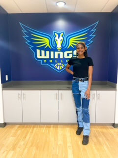 Quincy Noble in front of Wings logo