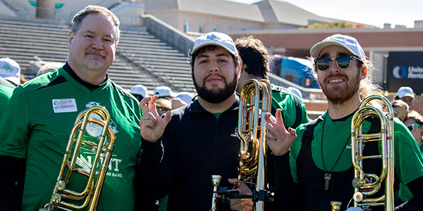 Green Brigade Alumni Band members pose with their instruments
