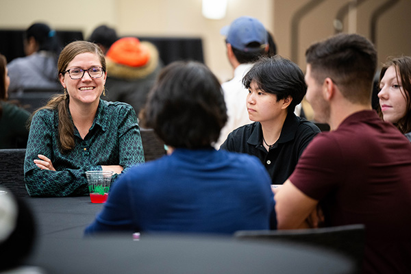 Volunteer speaker in conversation with UNT students